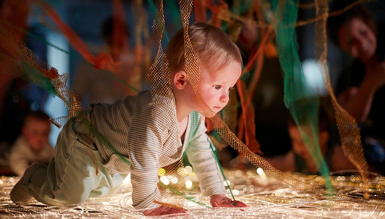 A photo of a baby crawling in a sensory play area