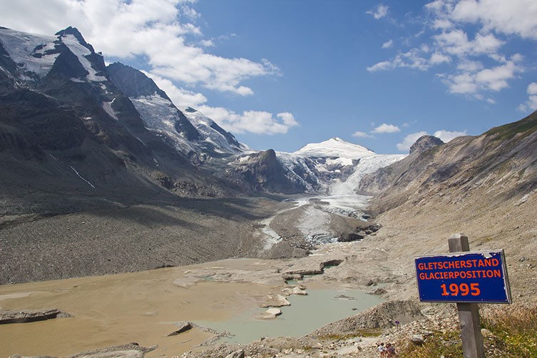 A sign marks where the Pasterze Glacier reached in 1995, with the receded glacier now far behind it