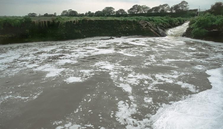 Foam floating on a river outside a sewage works
